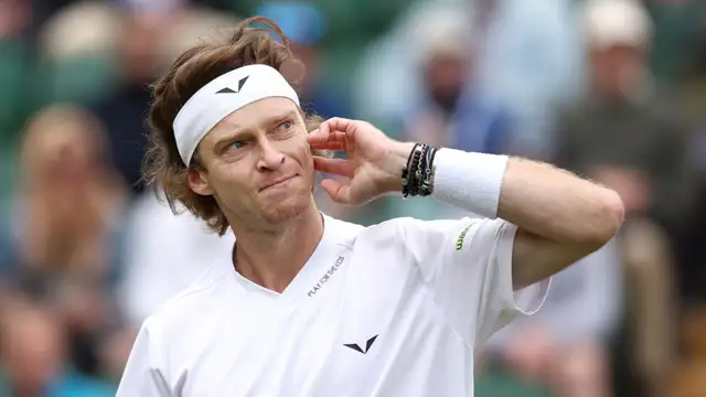 Russian tennis player Andrey Rublev expresses frustration by hitting himself with racquet during Wimbledon match