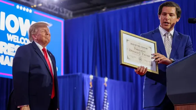 Republican candidate Joe Mitchell gives President Donald Trump a self-created 'Man of the Century Award' at Iowa rally